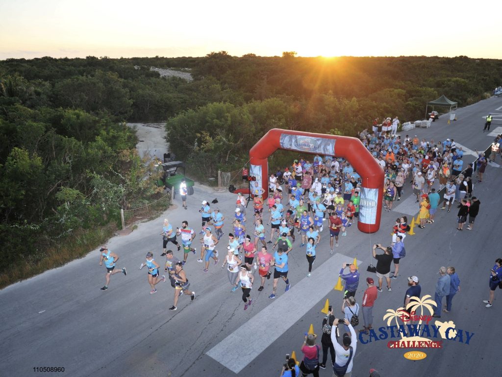 Runners crossing start line of the Castaway Cay Challenge at sunrise