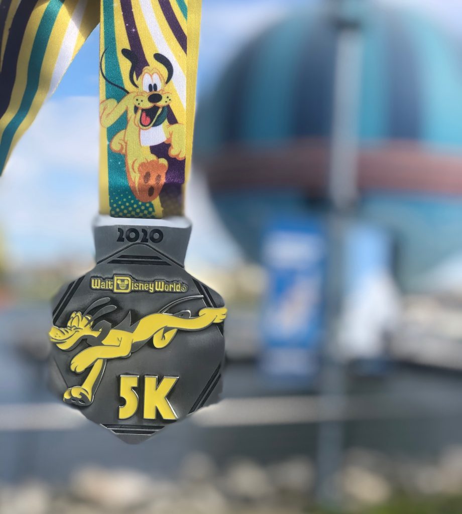 The 2020 Walt Disney World 5K medal featuring Pluto the Dog on a silver hexagon